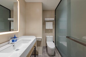 A modern bathroom with a white sink, a mirror, a toilet, and a glass shower enclosure. - Hanting Hotel Beijing Huilongguan North China Elec (Beijing)