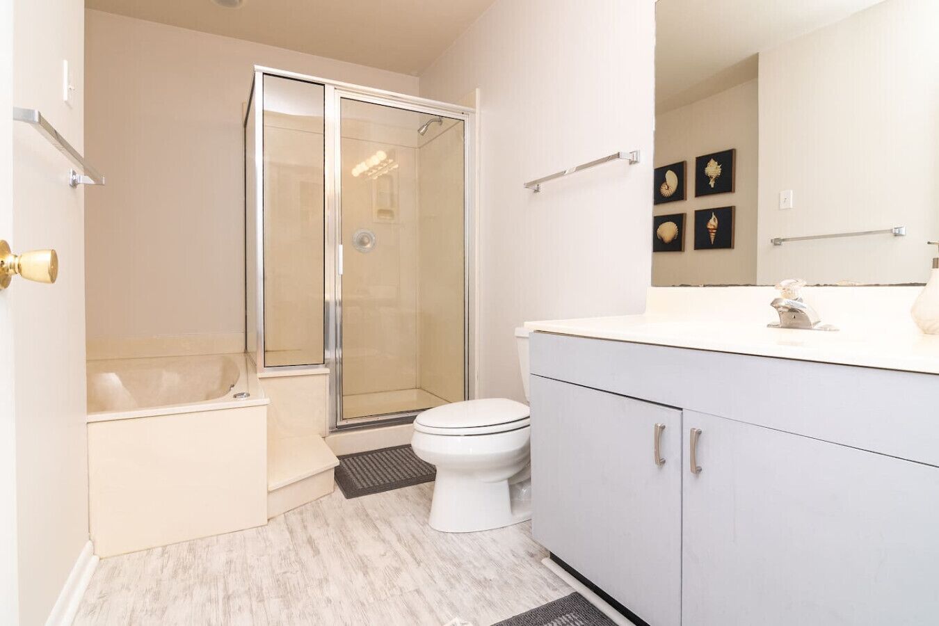 A modern bathroom with a glass-enclosed shower, a white toilet, and a vanity with cabinets.