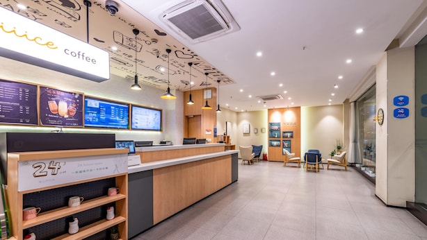 A coffee shop interior with a reception desk, digital menu boards, and seating area. - Hanting Hotel Hangzhou West Lake Culture Squa (Hangzhou)