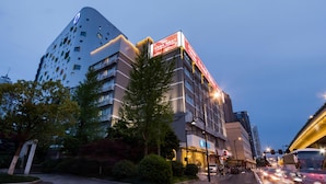 A multi-story hotel with a modern design, featuring a prominent signage and a well-lit facade. - Hanting Hotel Hangzhou West Lake Culture Squa (Hangzhou)