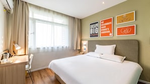 A hotel room with a large bed, a desk with a lamp, a chair, and a window with curtains. - Hanting Hotel Hangzhou West Lake Culture Squa (Hangzhou)