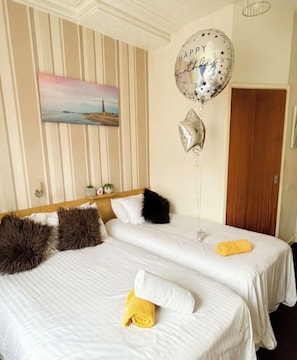 A hotel room with two beds, striped wallpaper, a painting, and a 'Happy Birthday' balloon. - All room types available - 3 minutes walk from the famous Blackpool Tower (Blackpool)