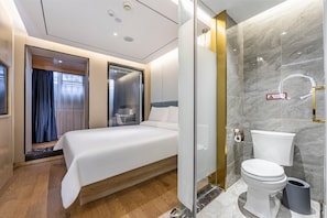 A hotel room with a bed, a bathroom with a toilet and a shower, and a glass partition. - Hanting Hotel (shanghai South Shanxi Road Metro St (Shanghai)