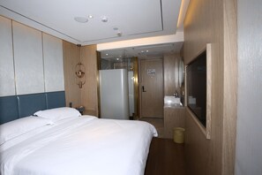 A hotel room with a bed, a bathroom with a mirror, and a door leading to another room. - Hanting Hotel (shanghai South Shanxi Road Metro St (Shanghai)