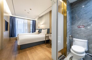 A modern hotel room with a large bed, a bedside table, a toilet, and a shower area. - Hanting Hotel (shanghai South Shanxi Road Metro St (Shanghai)