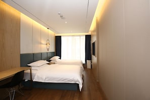 A hotel room with two beds, a desk, a chair, a TV, and a window with curtains. - Hanting Hotel (shanghai South Shanxi Road Metro St (Shanghai)