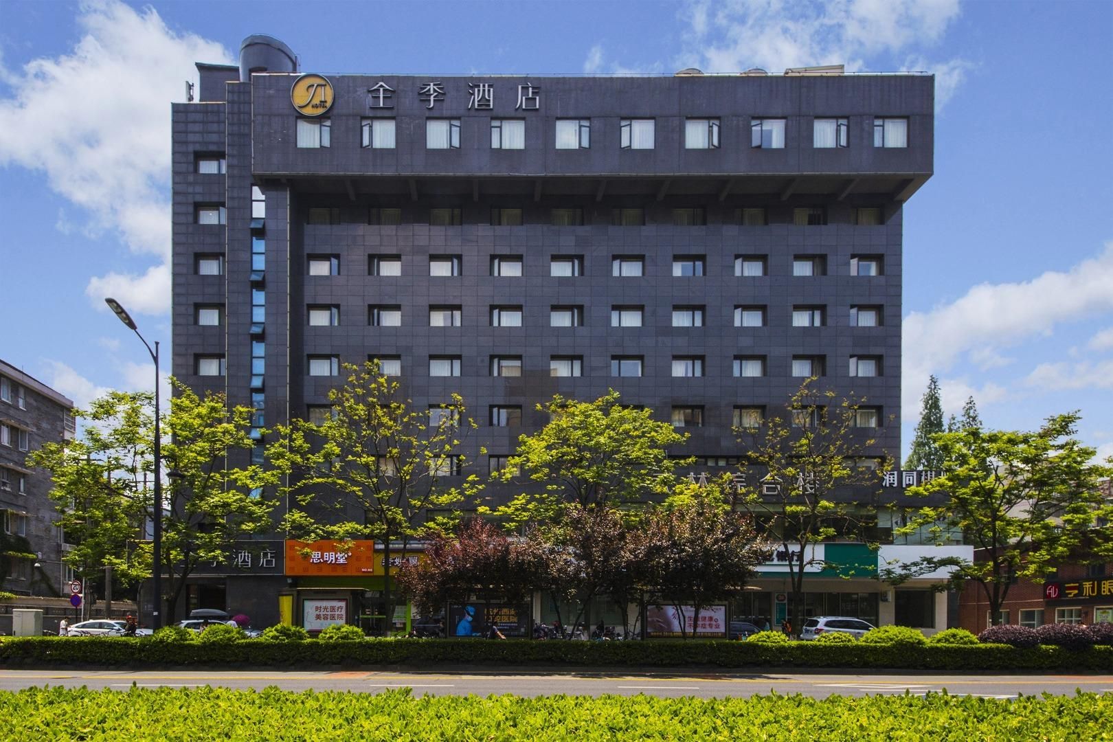 Un edifici d'hotel modern amb diverses plantes i un terrat pla.