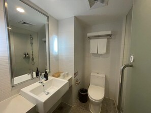 Moderni kylpyhuone, jossa on suuri peili, kylpyamme, wc ja suihku.