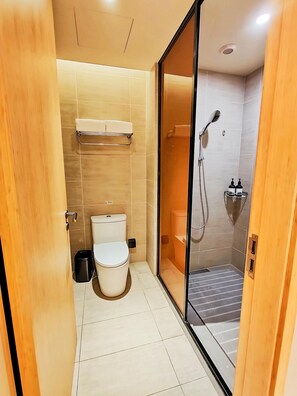 A modern bathroom with a toilet, a shower, and a glass-enclosed shower area. - Ji Hotel (hangzhou Future Science and Technology C (Hangzhou)