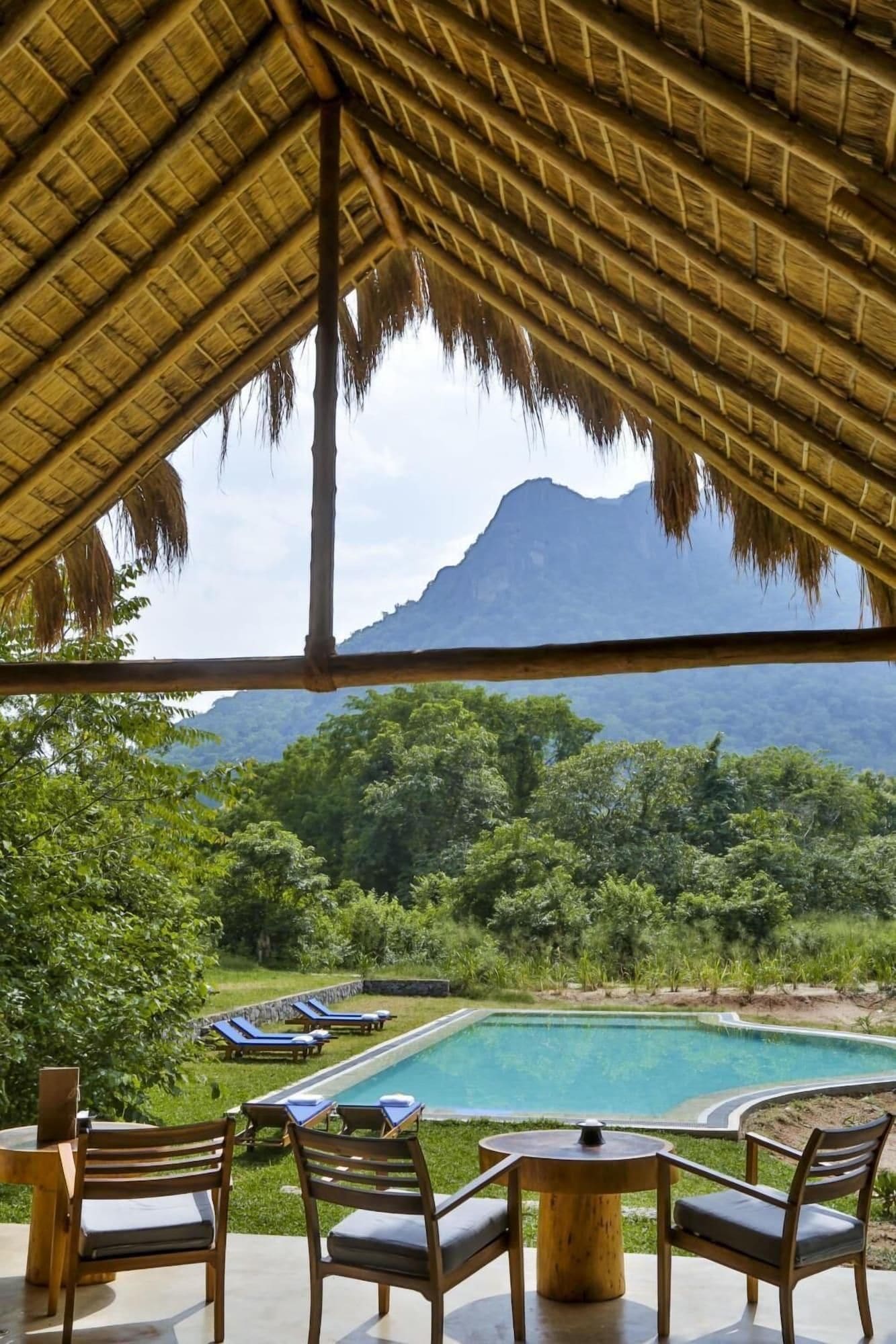 A poolside area with lounge chairs and a view of a mountain.