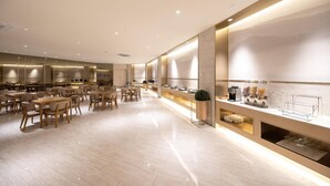 A modern hotel dining area with wooden tables and chairs, a buffet counter with various food items, and a clean, minimalist design. - Ji Hotel Hangzhou East Railway Station Qiutao N R (Hangzhou)