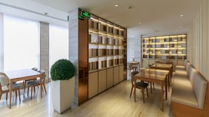 En modern hotellobby med en receptionsdisk, en sittgrupp och en bokhylla.