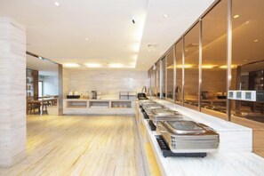 Un dispositiu de buffet modern amb diverses estacions de servei, un sòl de fusta i una paret separadora de vidre.
