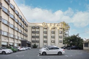 Un hotel de diverses plantes amb un aparcament al davant.