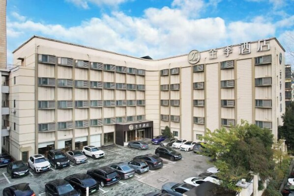Un hotel de diverses plantes amb un aparcament al davant.