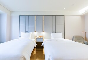 A modern hotel room with two single beds, a bedside table with a lamp, and a chair. - Ji Hotel (Luoyang)