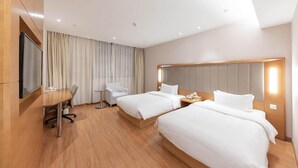 A hotel room with two beds, a desk, a chair, a TV, and a large window with curtains. - Ji Hotel Shanghai Jiayi Road Subway Statio (Shanghai)