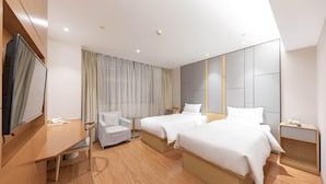 A hotel room with two beds, a TV, a desk, a chair, and a large mirror. - Ji Hotel Shanghai Jiayi Road Subway Statio (Shanghai)