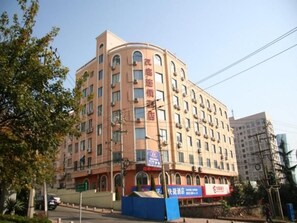 Ein mehrstöckiges Hotel mit geschwungener Fassade, zahlreichen Fenstern und einem Schild, das es als Hotel kennzeichnet.