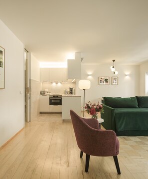 A modern apartment with a kitchen, a dining area, and a living room with a green sofa. - Lisbon Serviced Apartments - Principe Real (Lisbon)