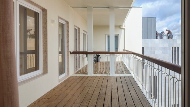 A wooden deck with railings, a view of the sky, and a building in the background. - Lisbon Serviced Apartments - Principe Real (Lisbon)