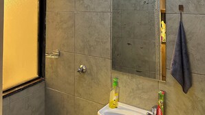 A bathroom with a shower, a sink with toiletries, and a towel rack. - Perfect 1-bedroom apartment with fitness gym in the building (Nairobi)