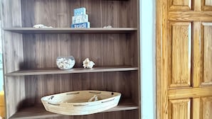 Una scaffalatura in legno con oggetti decorativi, una porta in legno e un pavimento piastrellato.
