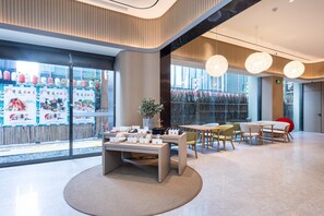 A modern interior with tables and chairs, large windows, and decorative hanging lights. - Ji Hotel (nanjing Xinjiekou Central Shopping Cente (Nanjing)