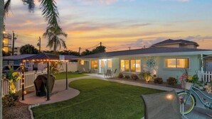 A residential house with a well-maintained lawn, a bicycle, and a white picket fence. - 03 minutes from the beach and famous restaurants. (Sarasota)