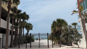 A gated area with palm trees, a beach, and a building with balconies. - 03 minutes from the beach and famous restaurants. (Sarasota)