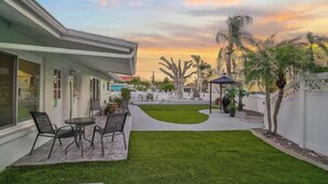 A patio with outdoor seating, a lawn, and a white fence. - 03 minutes from the beach and famous restaurants. (Sarasota)