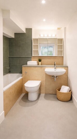A bathroom with a bathtub, toilet, sink, and a mirror above the sink. - Apartment Sleeps 2 With Wifi (London)