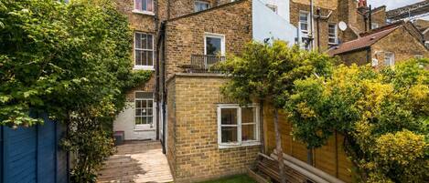 A residential property with a brick exterior, a small front yard, and a wooden deck.