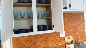 Una cocina con armarios blancos, encimera de madera y tabla de cortar.