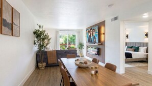 A modern dining area with a wooden table, chairs, and a bowl of fruit. - Pet-Friendly Branson Condo Sleeps 6~ Walk to Landing, Pools, Resort & Gym access (Branson)