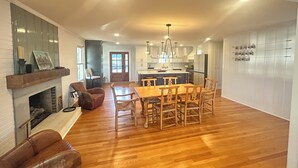 Una cocina amplia con comedor, suelo de madera y chimenea.