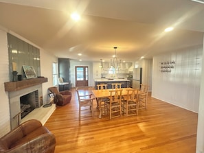 Una cocina amplia con comedor, suelo de madera y chimenea.