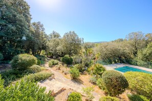 A landscaped garden with a swimming pool, stone pathways, and various shrubs and trees. - Lou Christalou - Avec Piscine privée (Carcès)