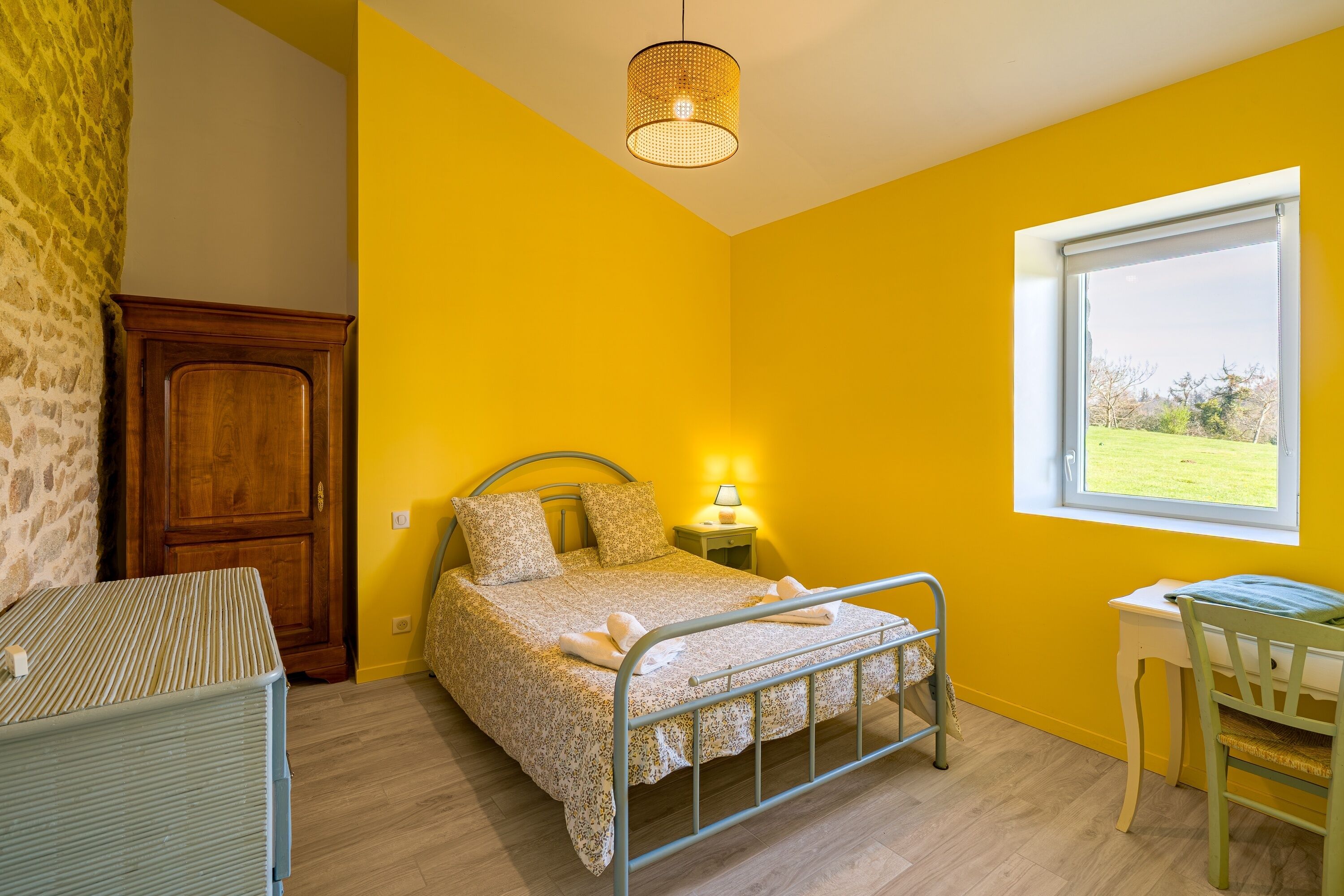 A room with a bed, a desk, a chair, a lamp, and a window.