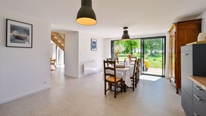 Un'ampia cucina con zona pranzo, ampie finestre e vista sull'esterno.