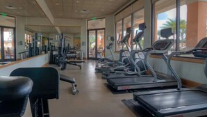 Ein Fitnessstudio mit Laufbändern, Kraftgeräten und einer Trainingsbank.