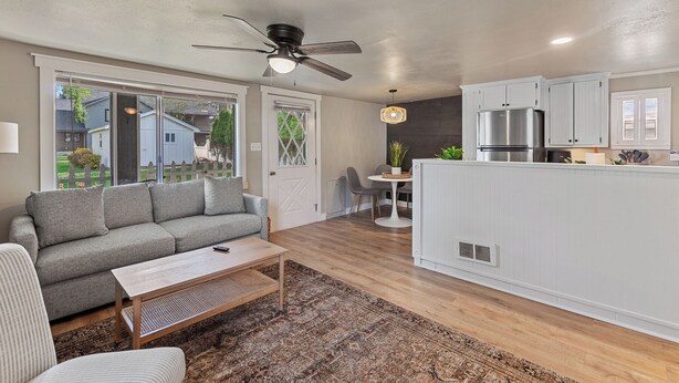 A modern living room with a sofa, coffee table, and a ceiling fan. - Charming CDA Cottage · Walk to Downtown & the Lake (Coeur d'Alene)