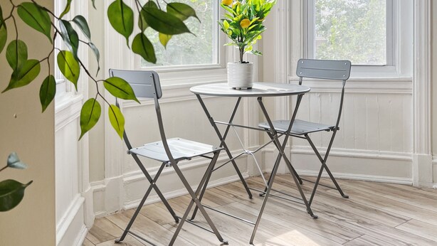 A room with a white-framed window, a potted plant on a small table, and two chairs. - Ramblei near Drexel Park: 6-Bedroom Unit B (Philadelphia)