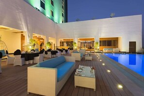 A rooftop pool area with outdoor seating and a dining setup. - Saura Hotel Agra A Club Mahindra (Agra)