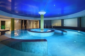 A circular indoor pool with a central pillar, surrounded by a curved wall and a glass ceiling. - Occidental Menorca (Sant Lluis)