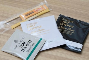 Variedad de productos de té y café, incluyendo una bolsita de té blanco noble, café de filtro y crema de café.