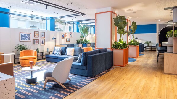 A modern lounge area with sofas, chairs, and potted plants. - Amazonia Lisboa Hotel (Lisbon)
