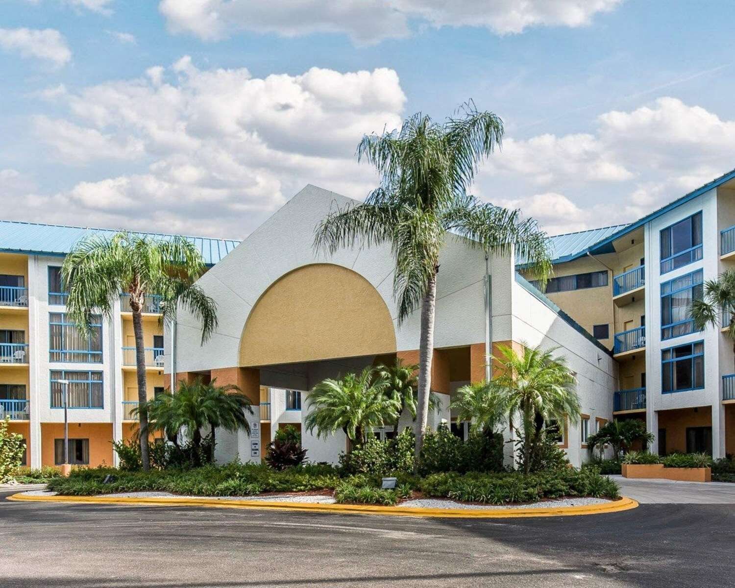 Un hotel con un atrio central, varios pisos y un estacionamiento.