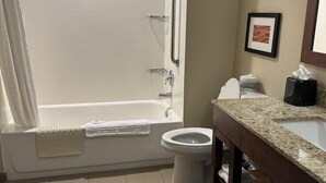 A bathroom with a bathtub, toilet, and sink.