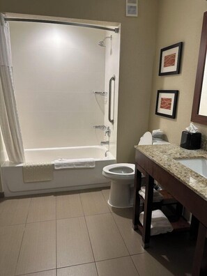 Un baño con bañera, inodoro y lavamanos.